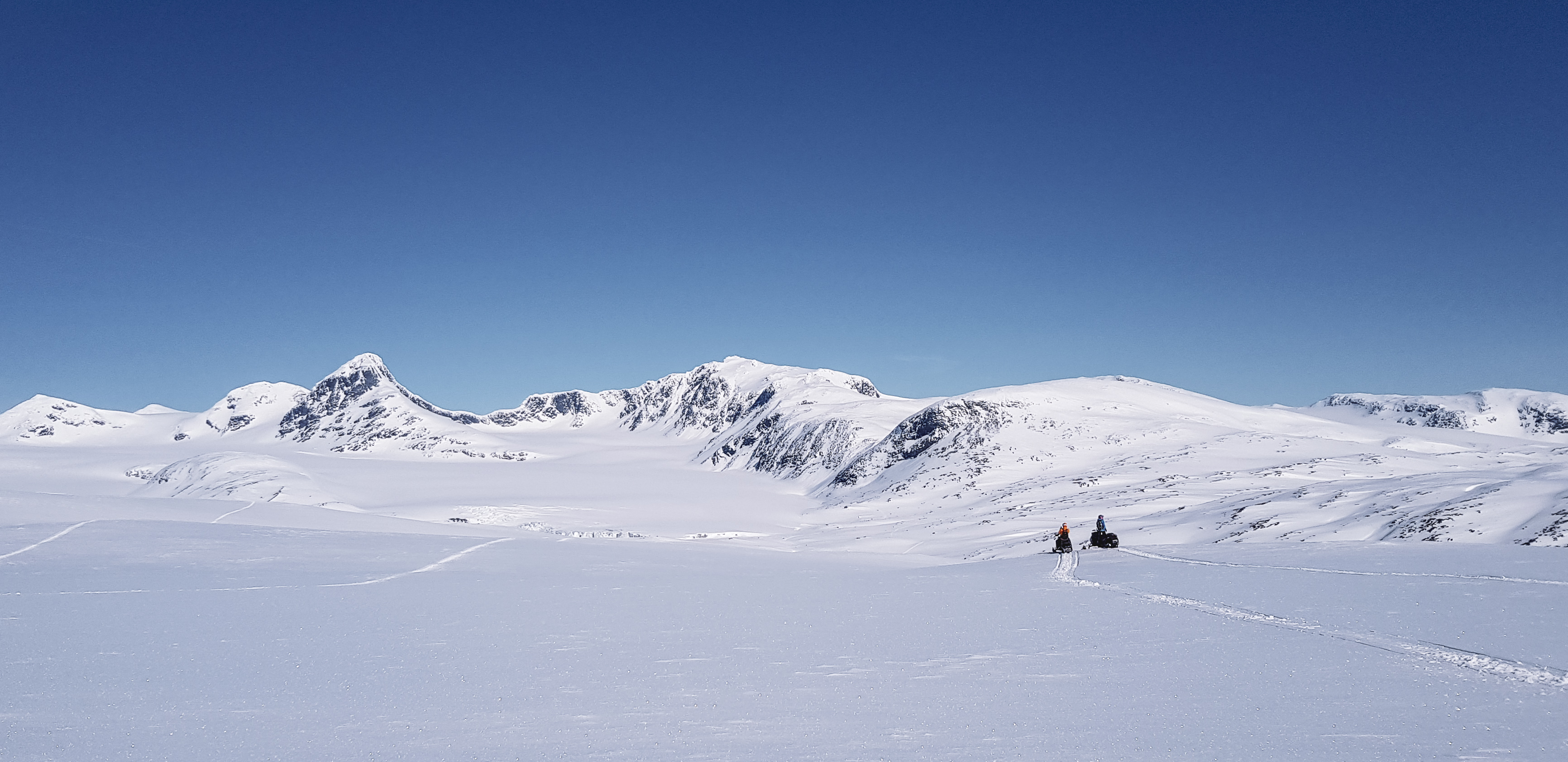 Snöskotrar framför glaciären Salajekna