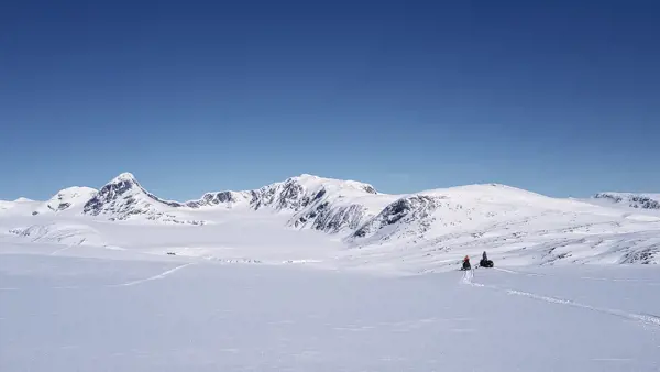 Snöskotrar framför glaciären Salajekna